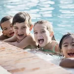 Summer Camp at Skipwith Academy - children in a pool laughing and smiling