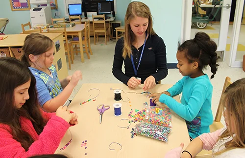 Skipwith Academy before and after school care - Youth Zone - girls making bead jewelry together