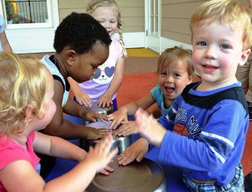 Skipwith Academy - Childcare in and around Richmond VA including daycare for infants and toddlers, preschool, before and after school care, montessori, summer camp, and more - image of children playing musical instruments together and laughing