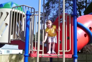 Skipwith Academy Colonial Heights smiling child on playground equipment - childcare in Colonial Heights Virginia, including infant and toddler daycare, preschool, before and after school care, and more