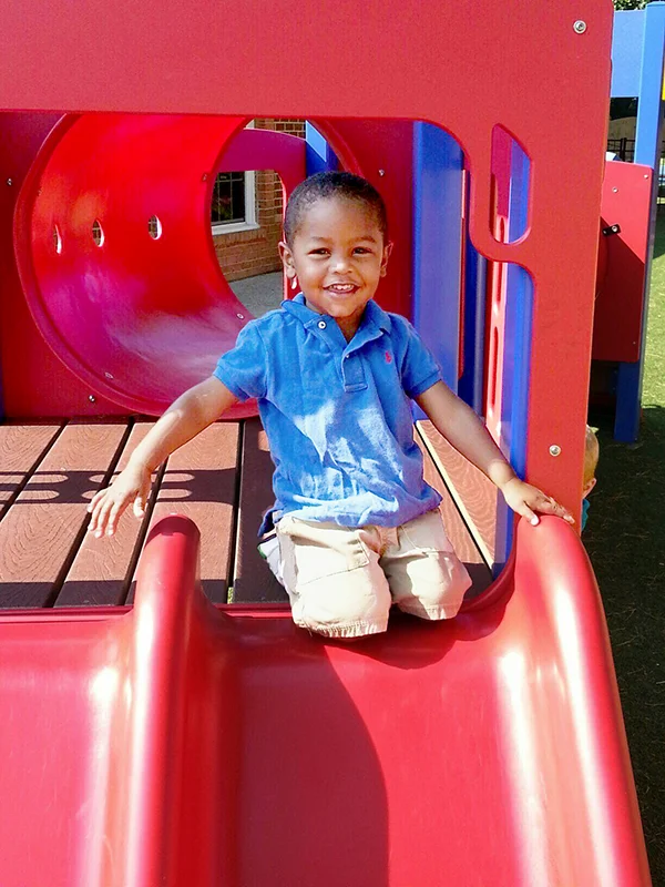 Skipwith Academy Enrollment - child smiling on playground equipment