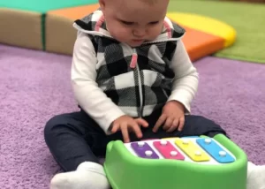 Skipwith Academy Lauderdale Square toddler with toy xylophone