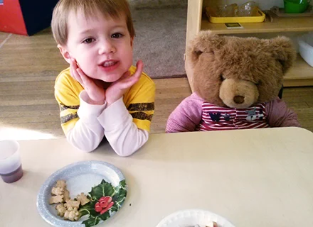 Skipwith Academy Goal - image of boy smiling with teddy bear in chair beside him