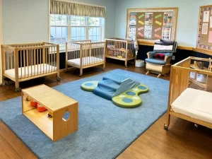 Skipwith Academy at Hanover - childcare in Ashland, Virginia, near Richmond - baby steps room featuring cribs, rocking chair, and toys for infants