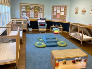 Skipwith Academy at Hanover - childcare in Ashland, Virginia, near Richmond - baby steps room featuring cribs, rocking chair, and toys for infants